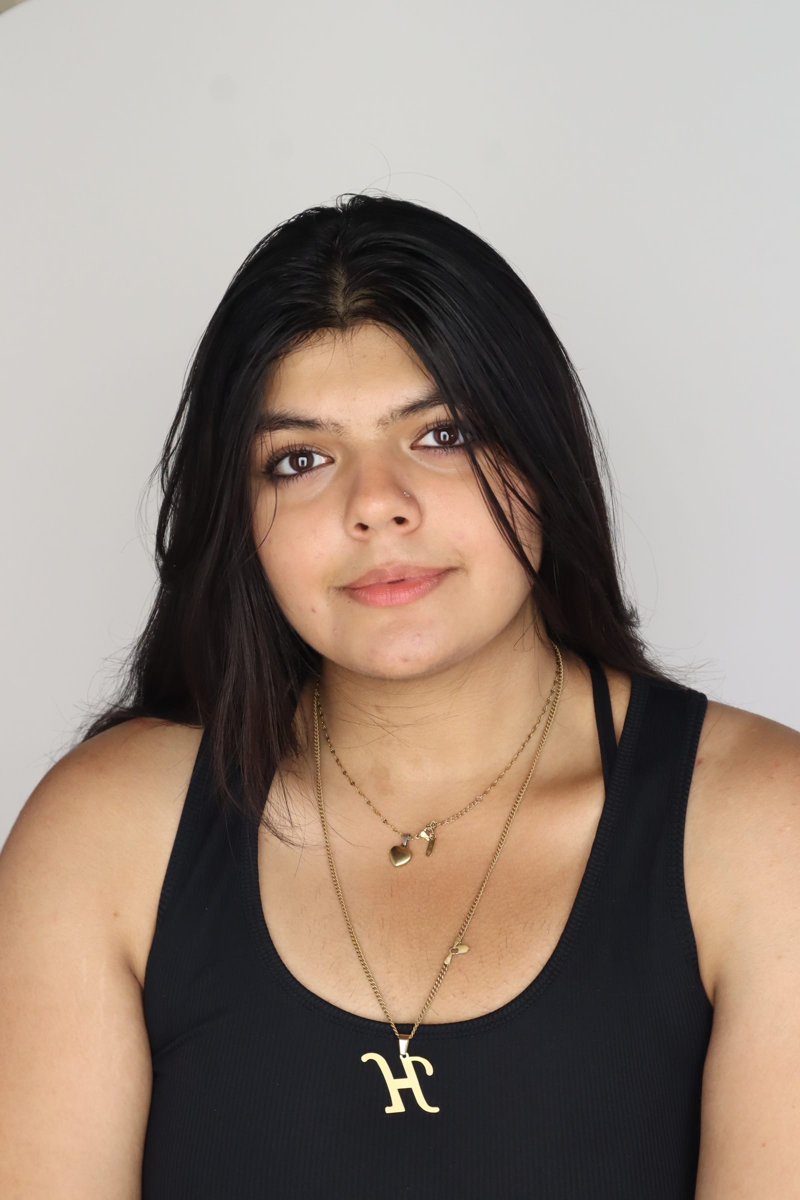 Himani Jamwal headshot, soft smile, black top against a grey studio backdrop